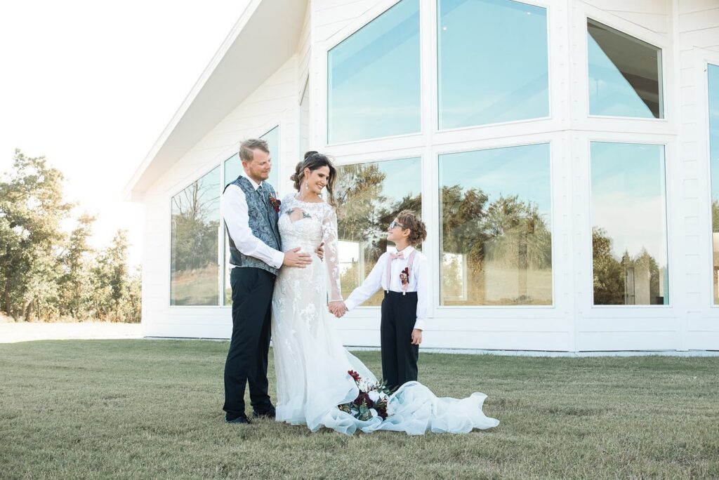 bride and groom holding son's hand