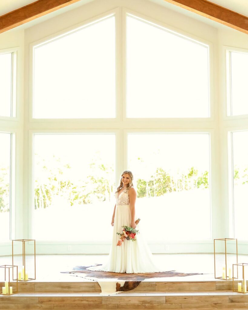 bride standing in front of large windows