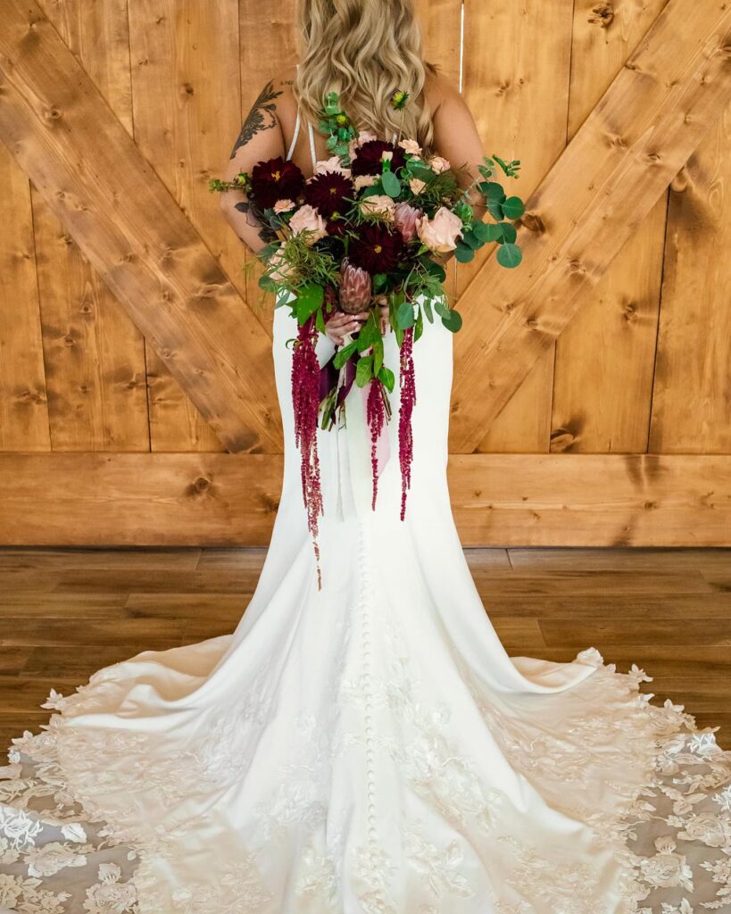 bride holding burgundy and pink bridal bouquet