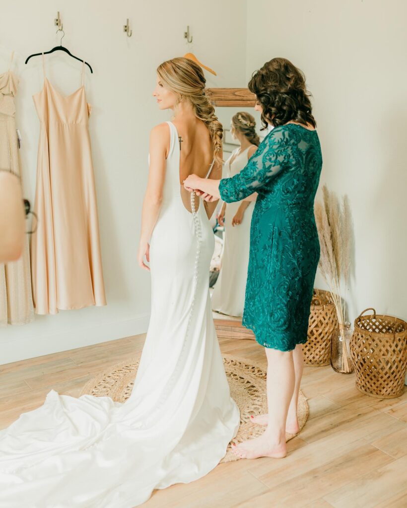 bride's mother buttoning bride's gown