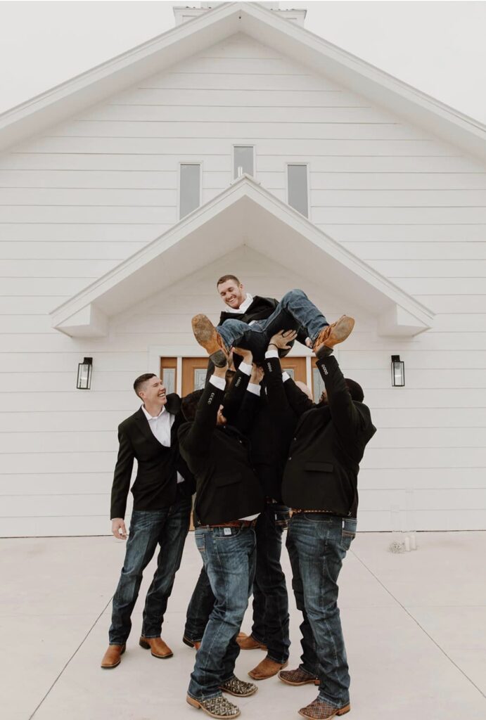groomsmen lifting up groom
