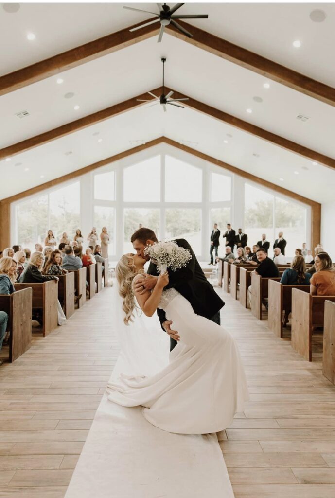 bride and groom kissing in aisle after ceremony